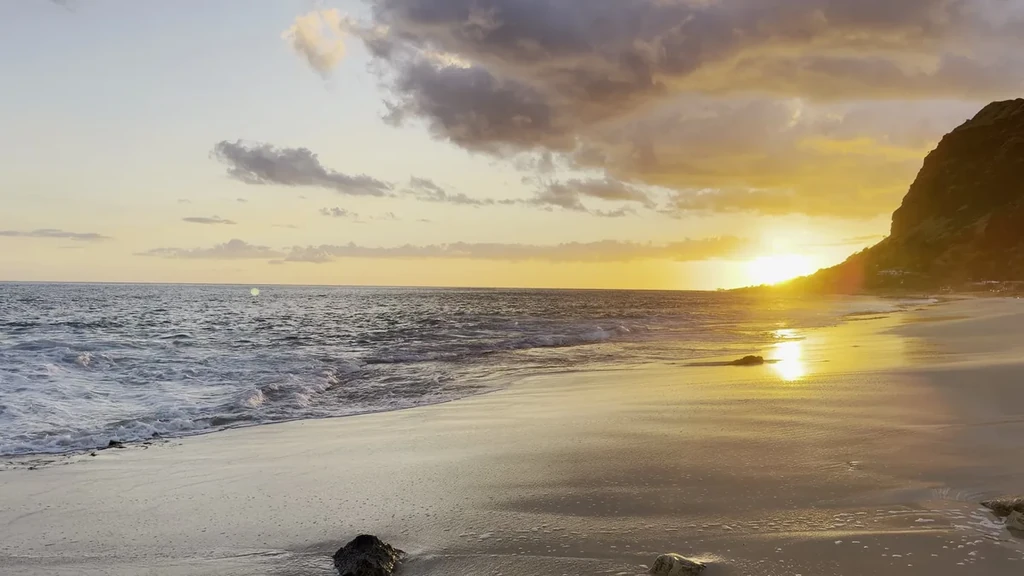 The original coastal photograph, with waves and sunlight on the water.