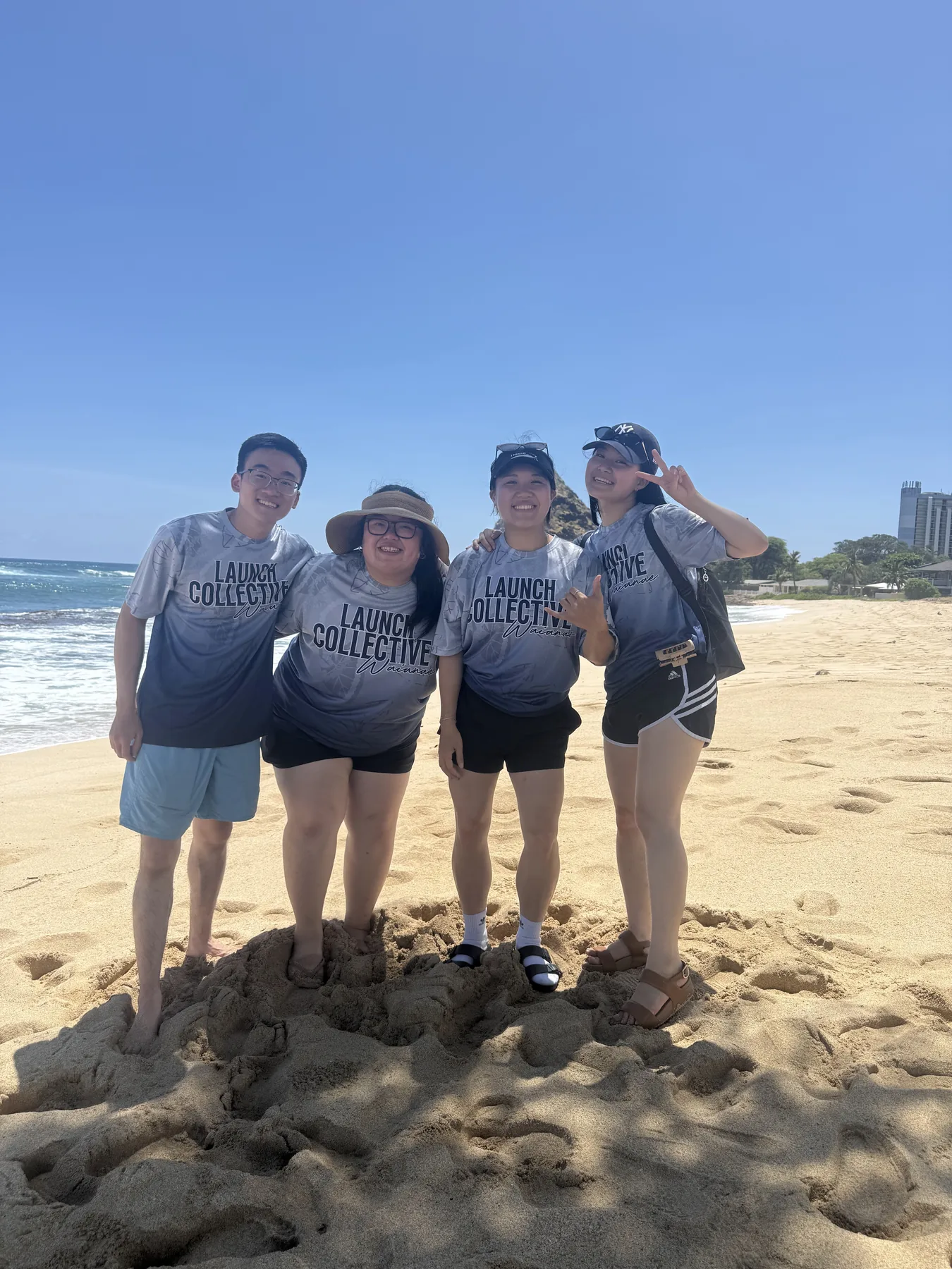 Four team members standing together on the beach after cleanup.