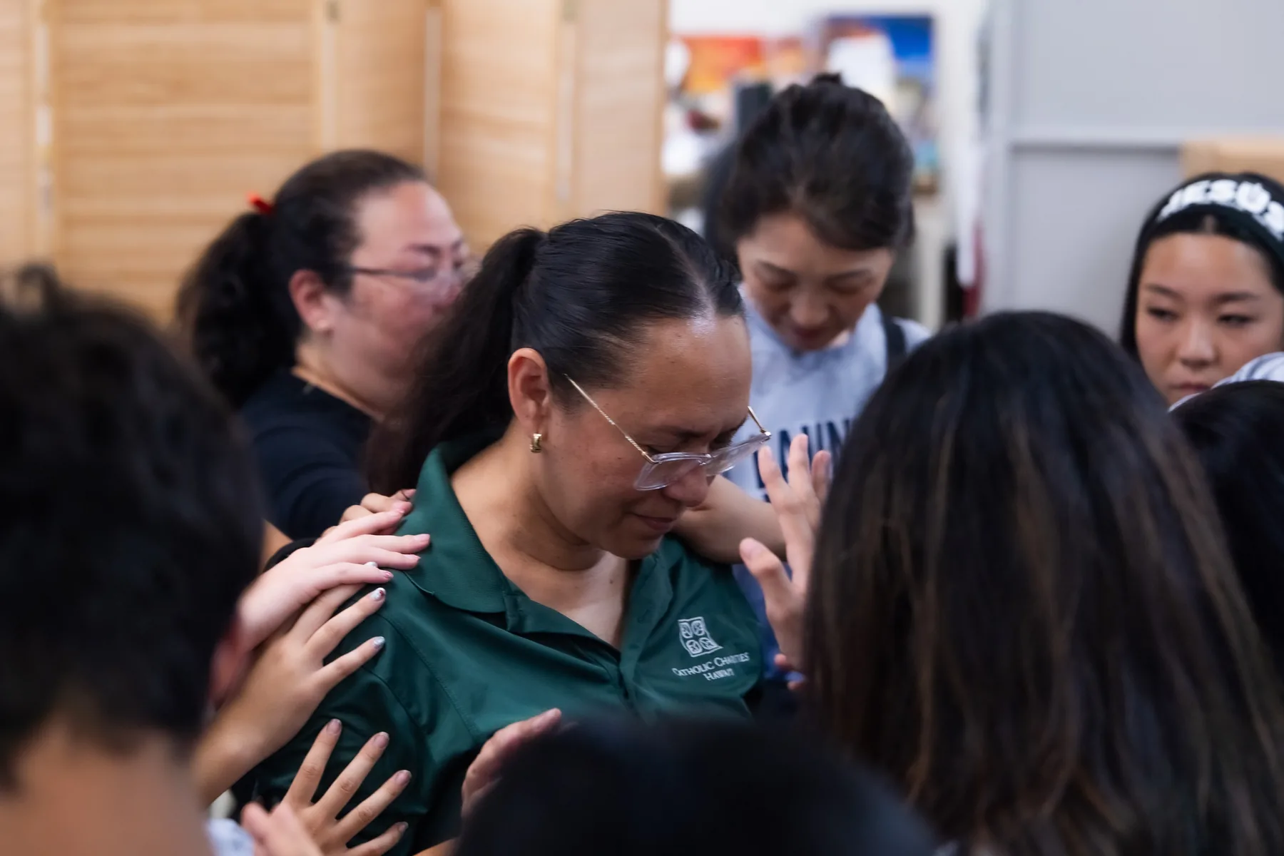 The team gathered around a woman in prayer.