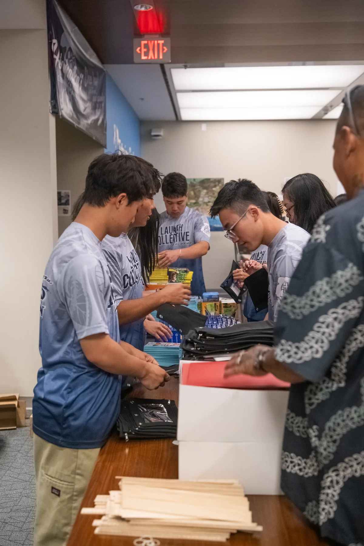 Team members packing school supplies into bags.