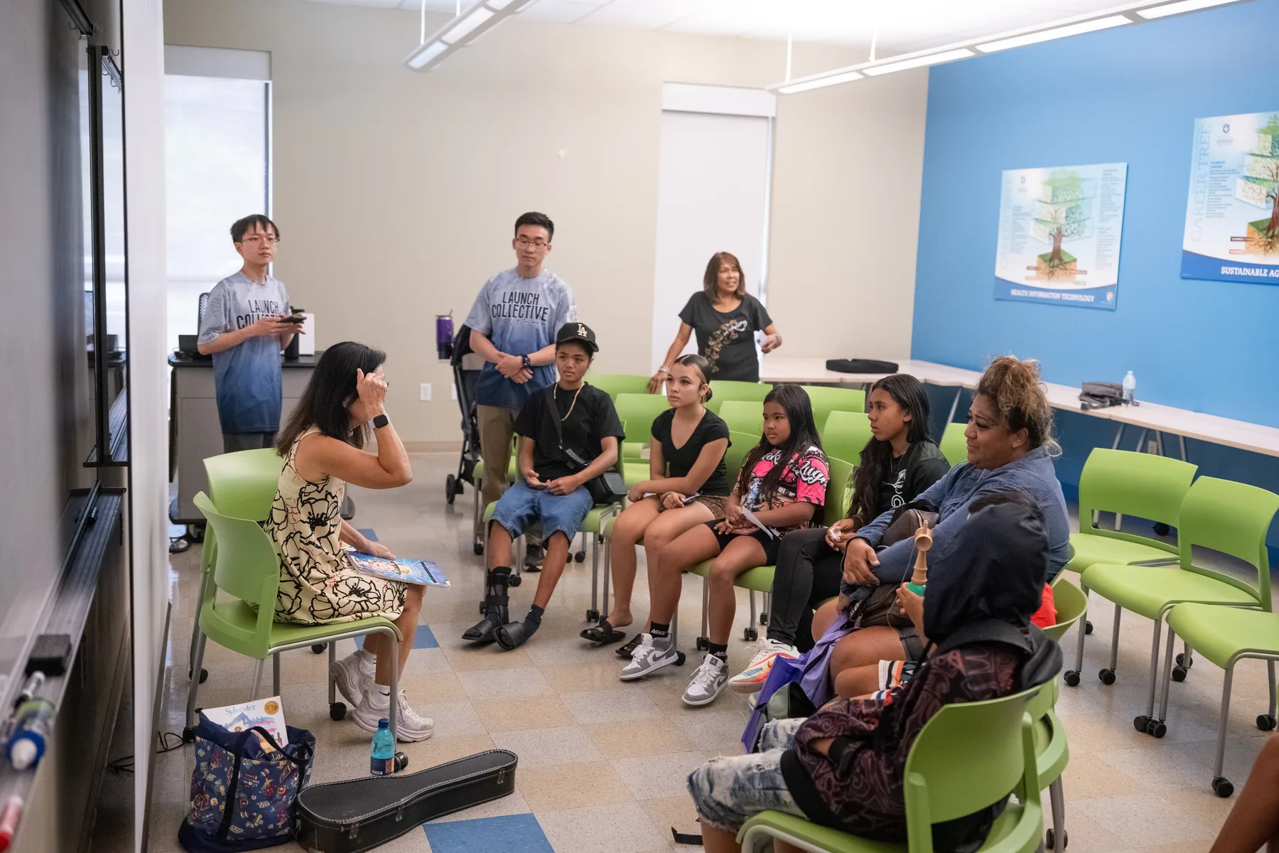 Team members reading books to children in a small classroom.