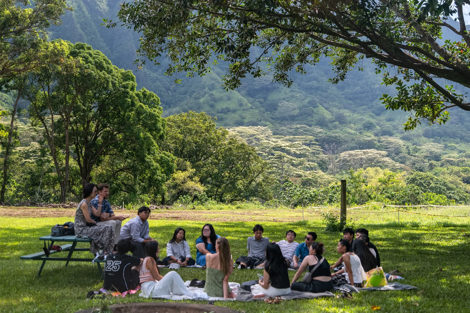 The team sitting on blankets in the grass for testimony sharing.
