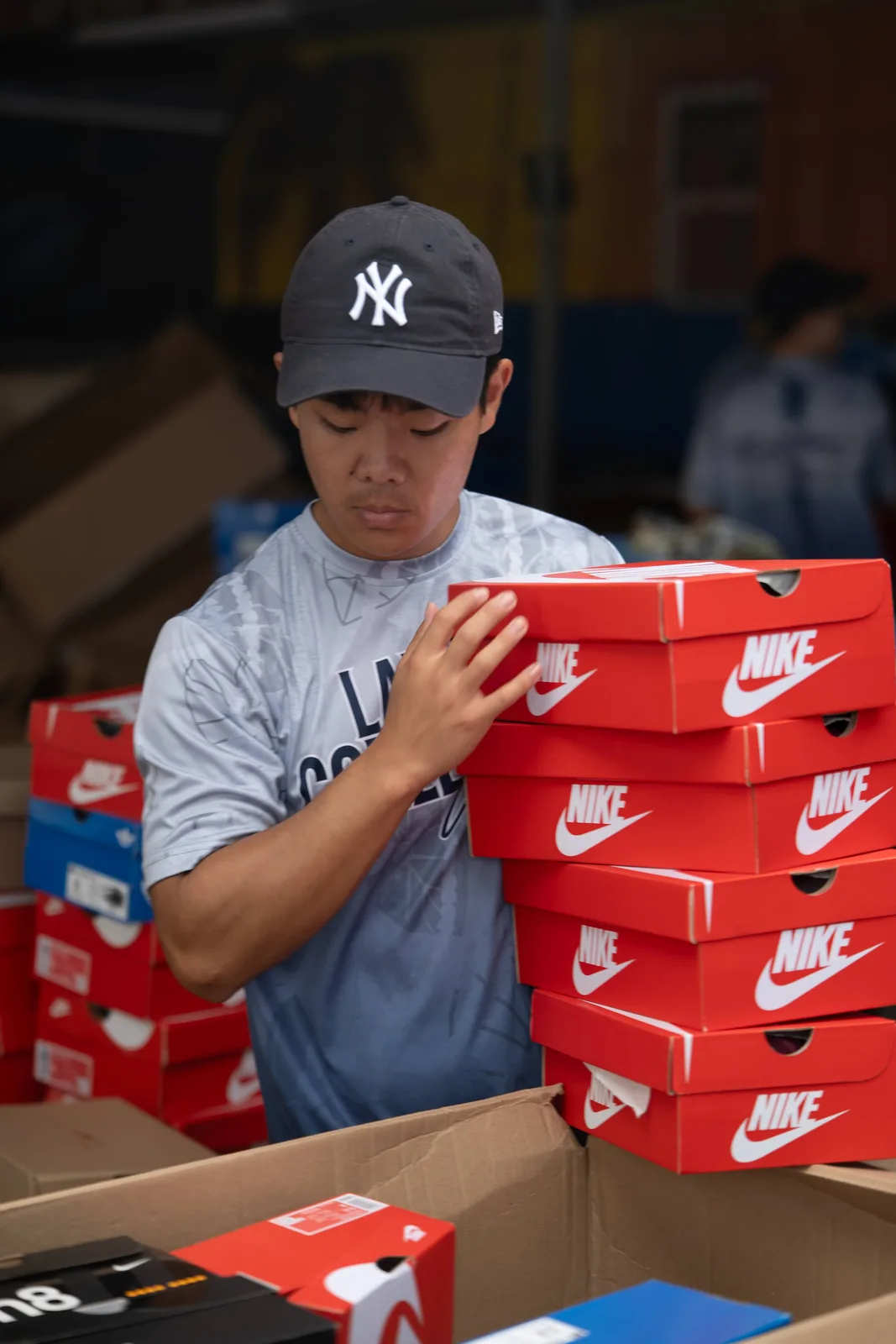 Team member stacking red Nike shoe boxes during shoe sorting.