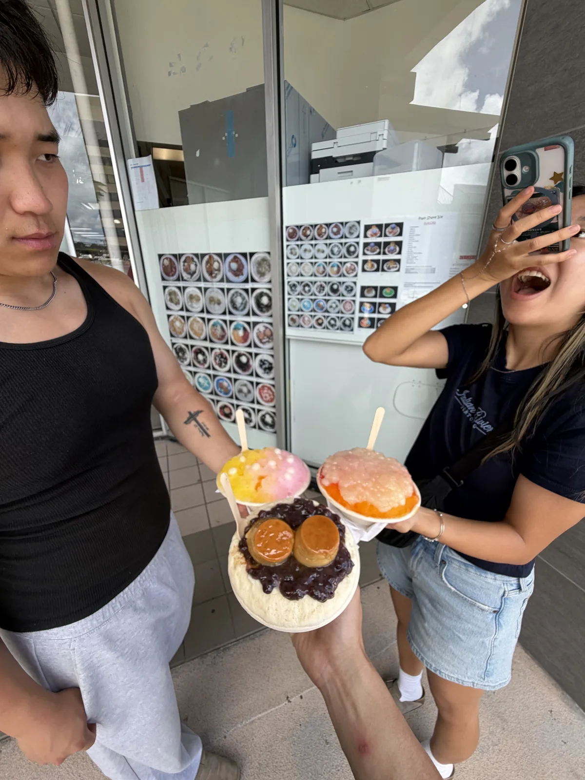 Friends holding shave ice outside a local shop.